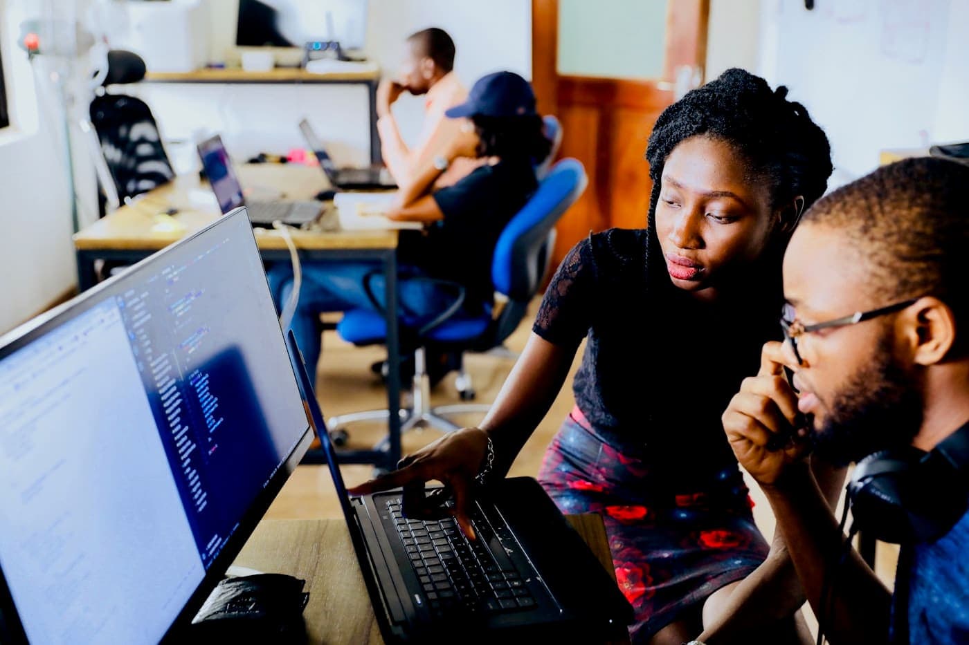 African engineers collaborating over code in a modern workspace